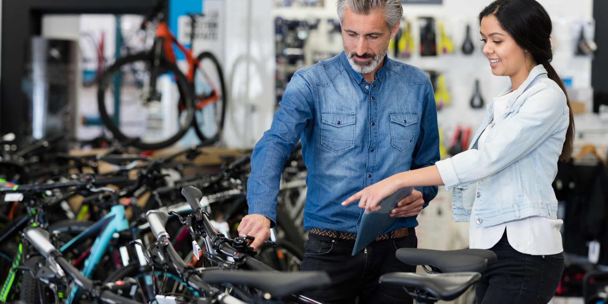 Eine Verkäuferin berät einen Kunden in einem Bike-Geschäft.