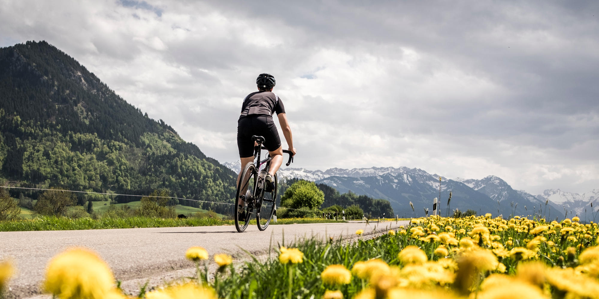 Rennradfahrer fährt durch bergige Landschaft.