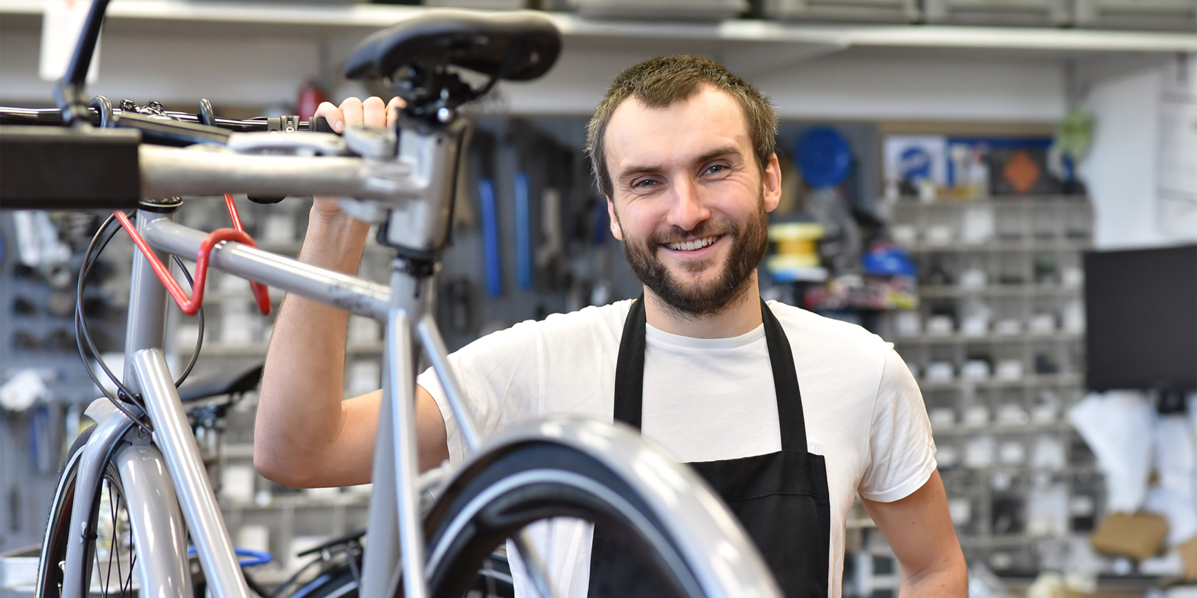 Mann mit Fahrrad in Werkstatt