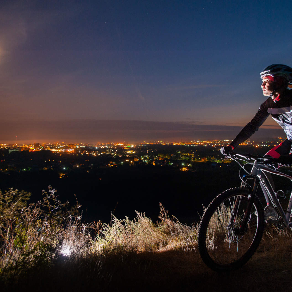 Ein Fahrradfahrer beobachtet den Mond im Dunkeln