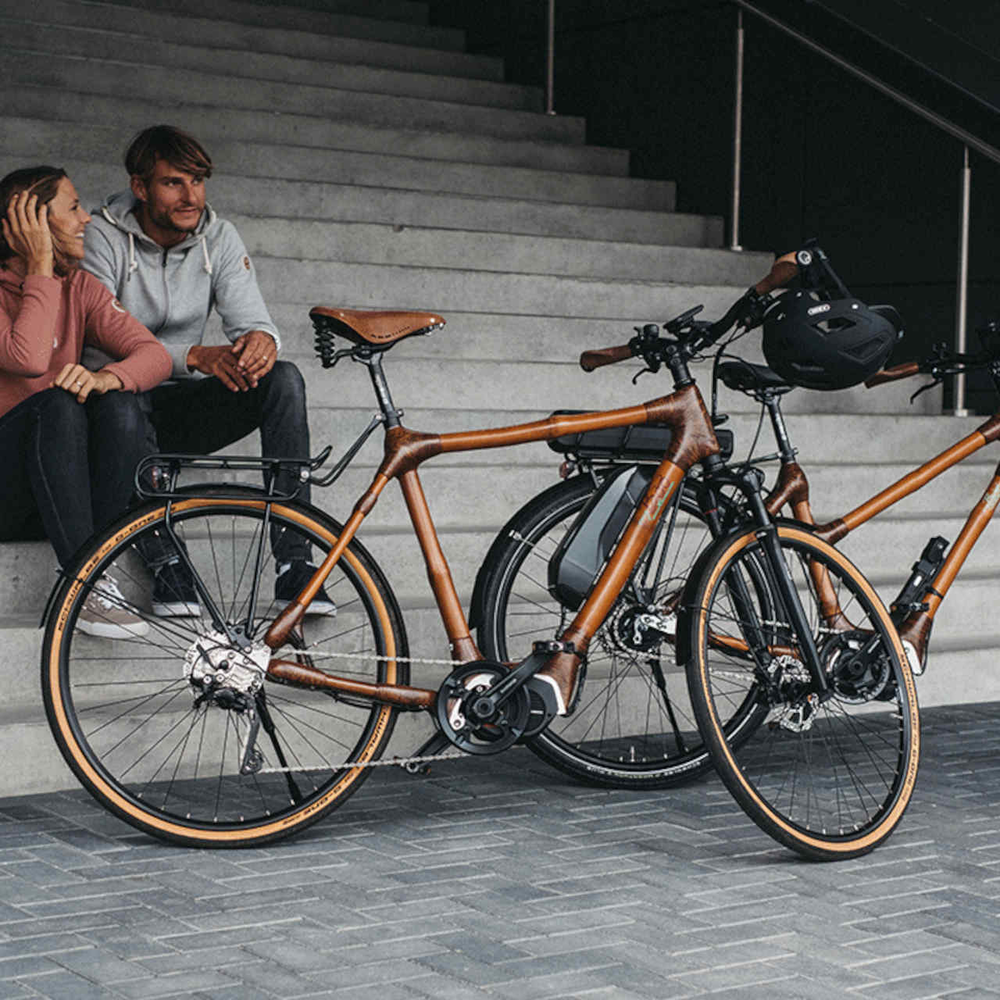 Zwei Personen sitzen neben Bambus-E-Bikes