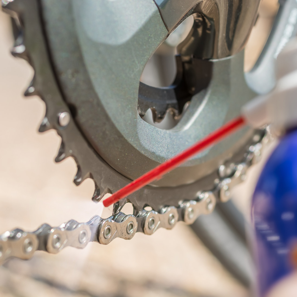 Kettenöl- wird auf eine Fahrradkette gesprüht