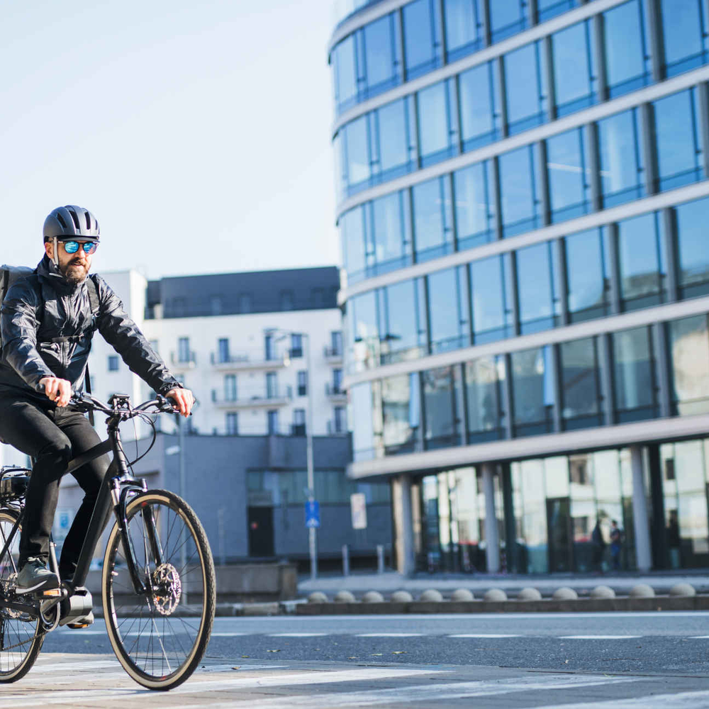 Mann mit Helm fährt auf E-Bike.