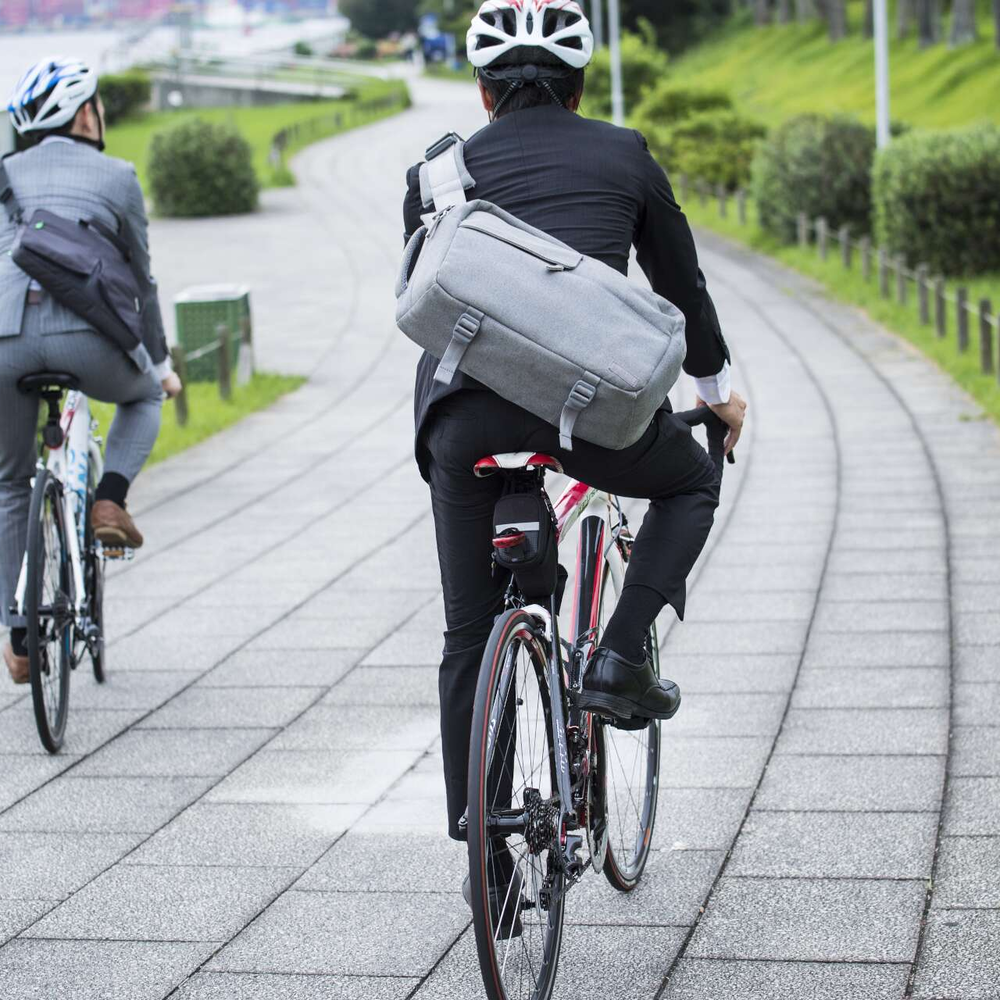 Zwei Männder in Businesskleidung fahren mit dem Fahrrad. 