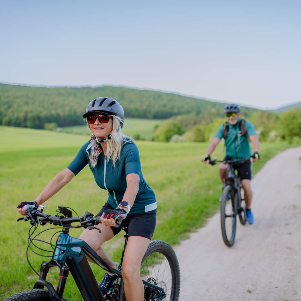 Ein Paar fährt in der Natur E-Bike