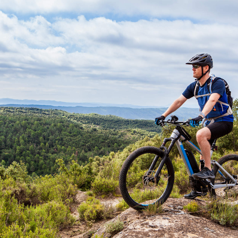 Ein Mann fährt E-Mountainbike in den Bergen