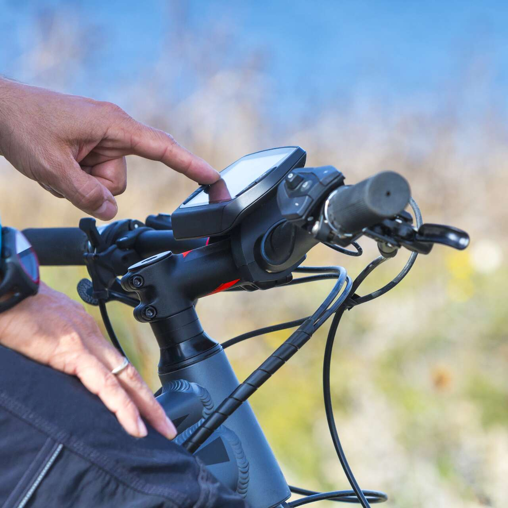 Ein Mann tippt auf dem Touch-Display seines Fahrrad-Computers.