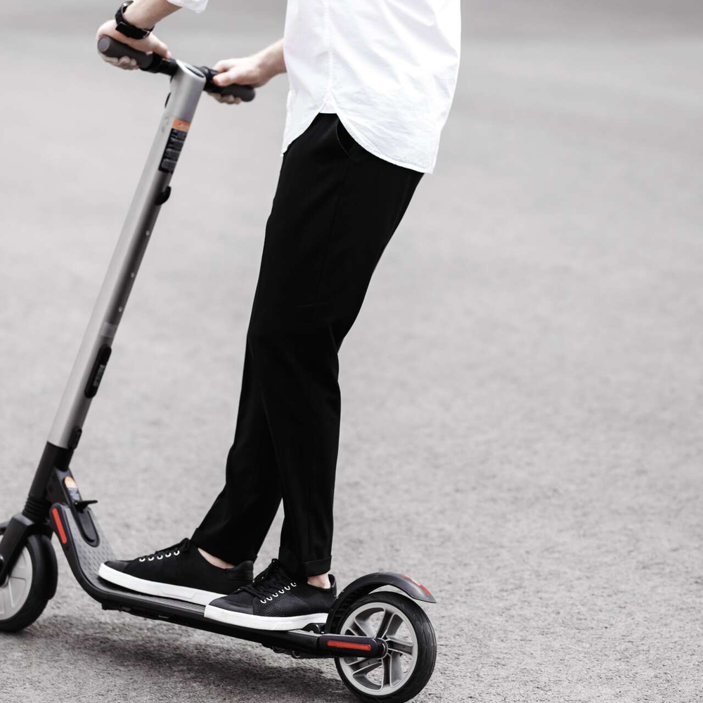 Person steht auf einem E-Scooter