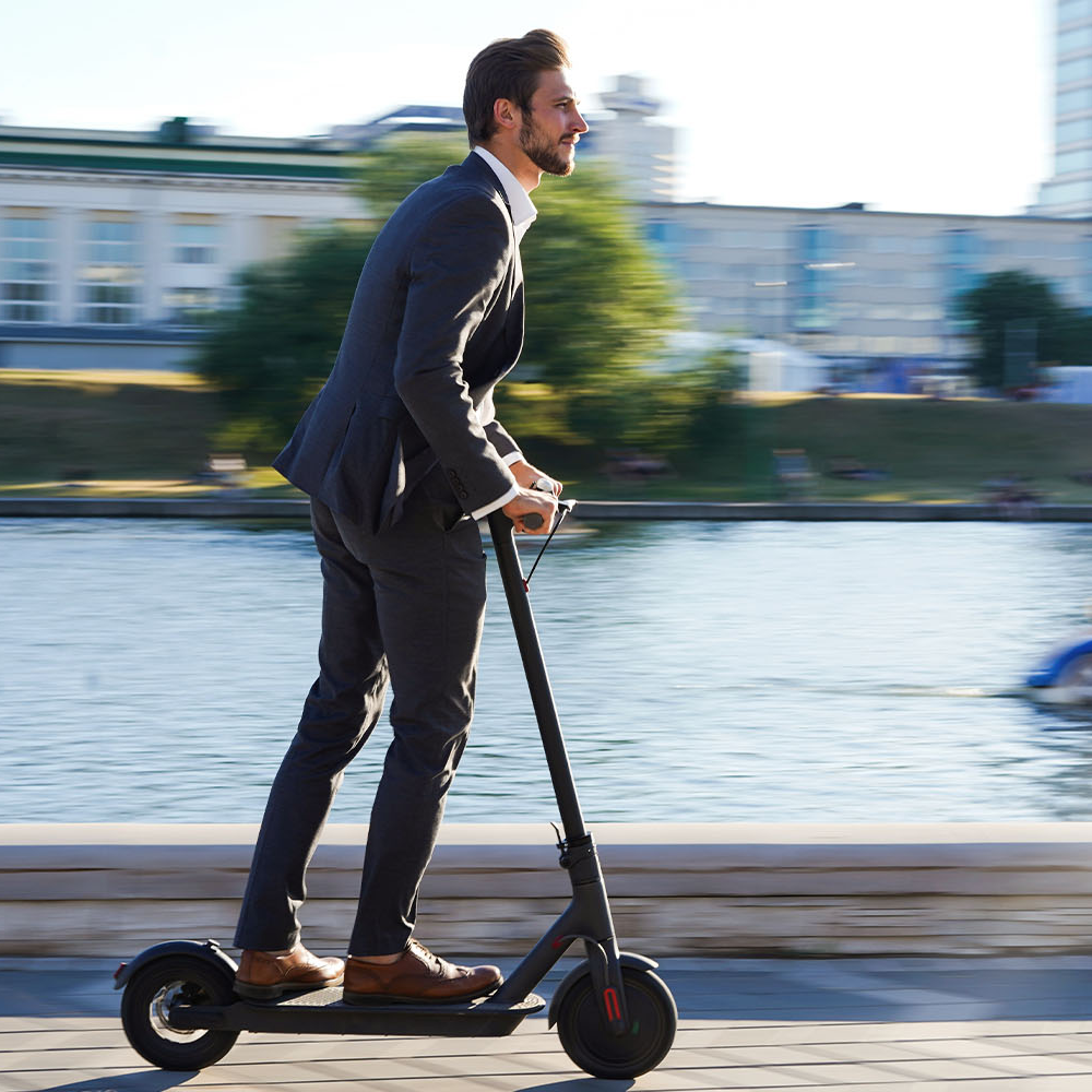 Mann fährt durch Stadtverkehr auf einem E-Scooter