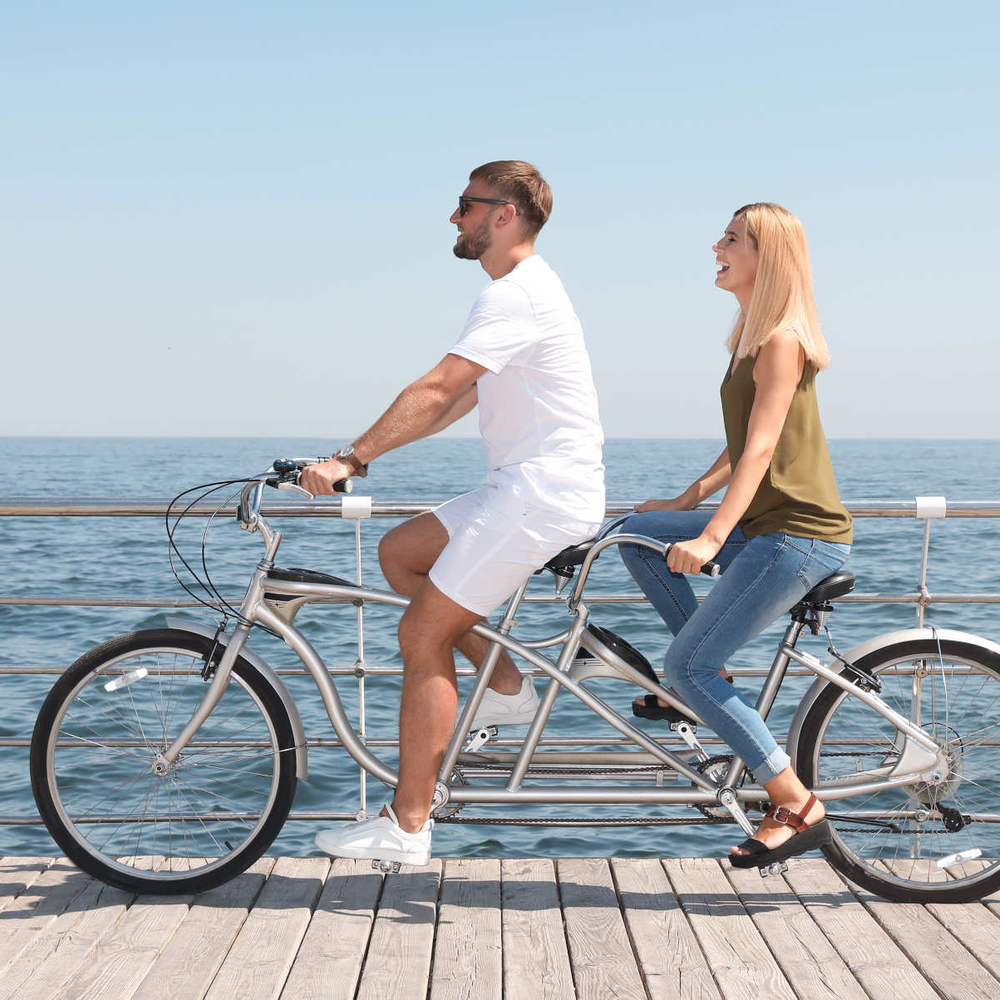 Mann und Frau sitzen auf Tandem E-Bike.