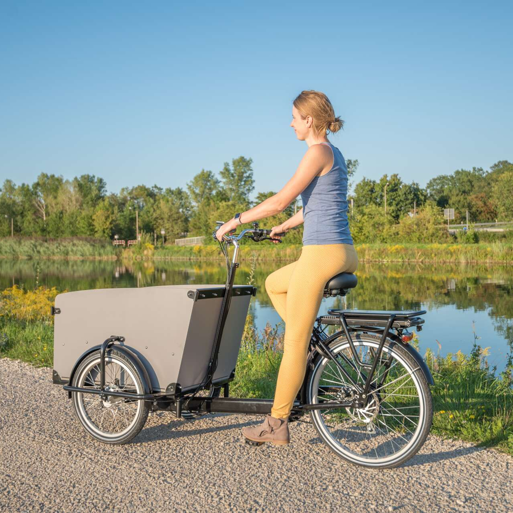 Frau fährt auf einem Lastenrad.