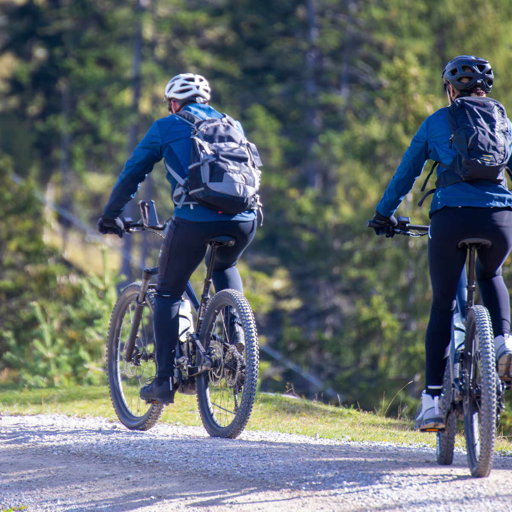 Zwei Frauen fahren auf E-Mountainbike durch die Berge.