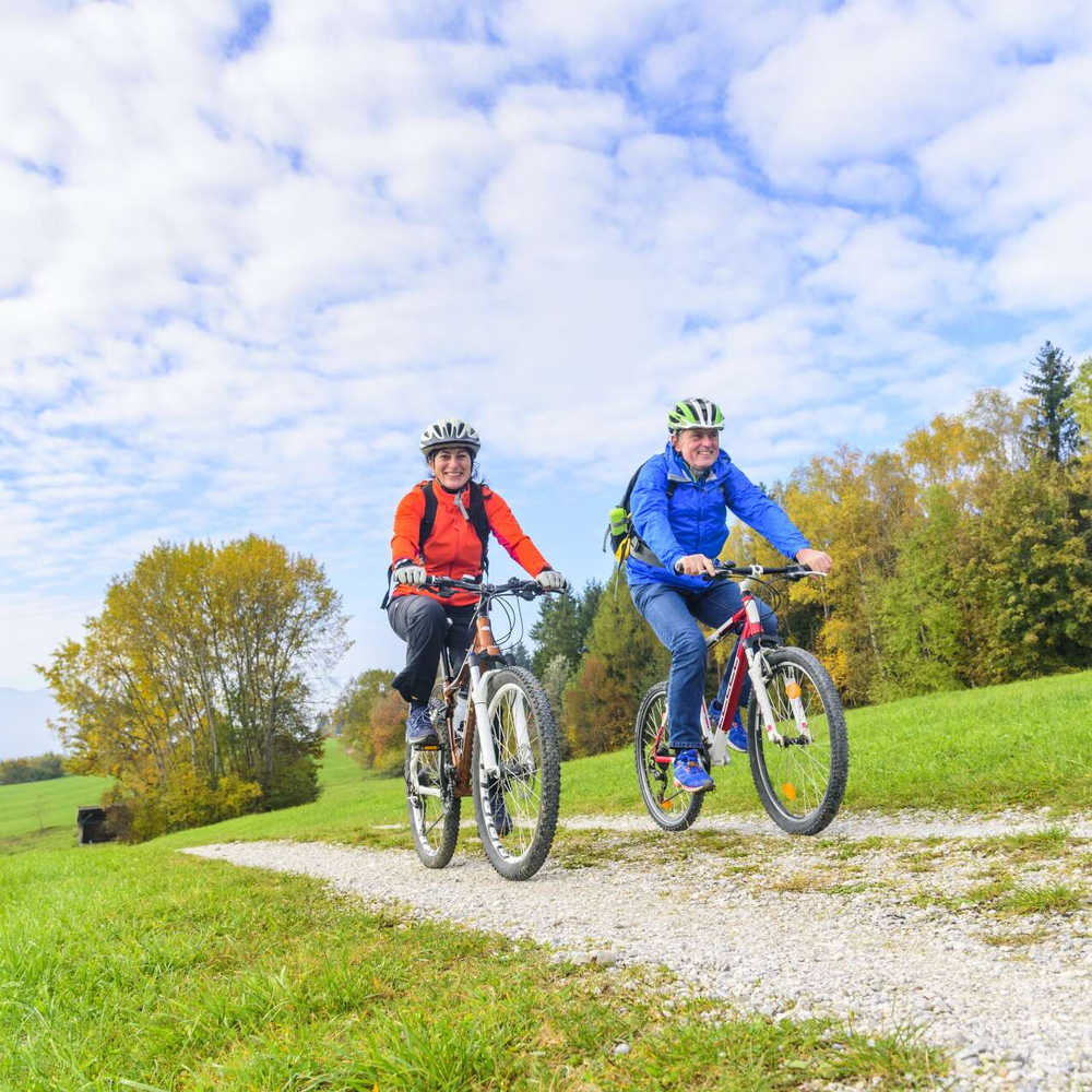 Zwei Personen fahren in der Natur Fahrrad.