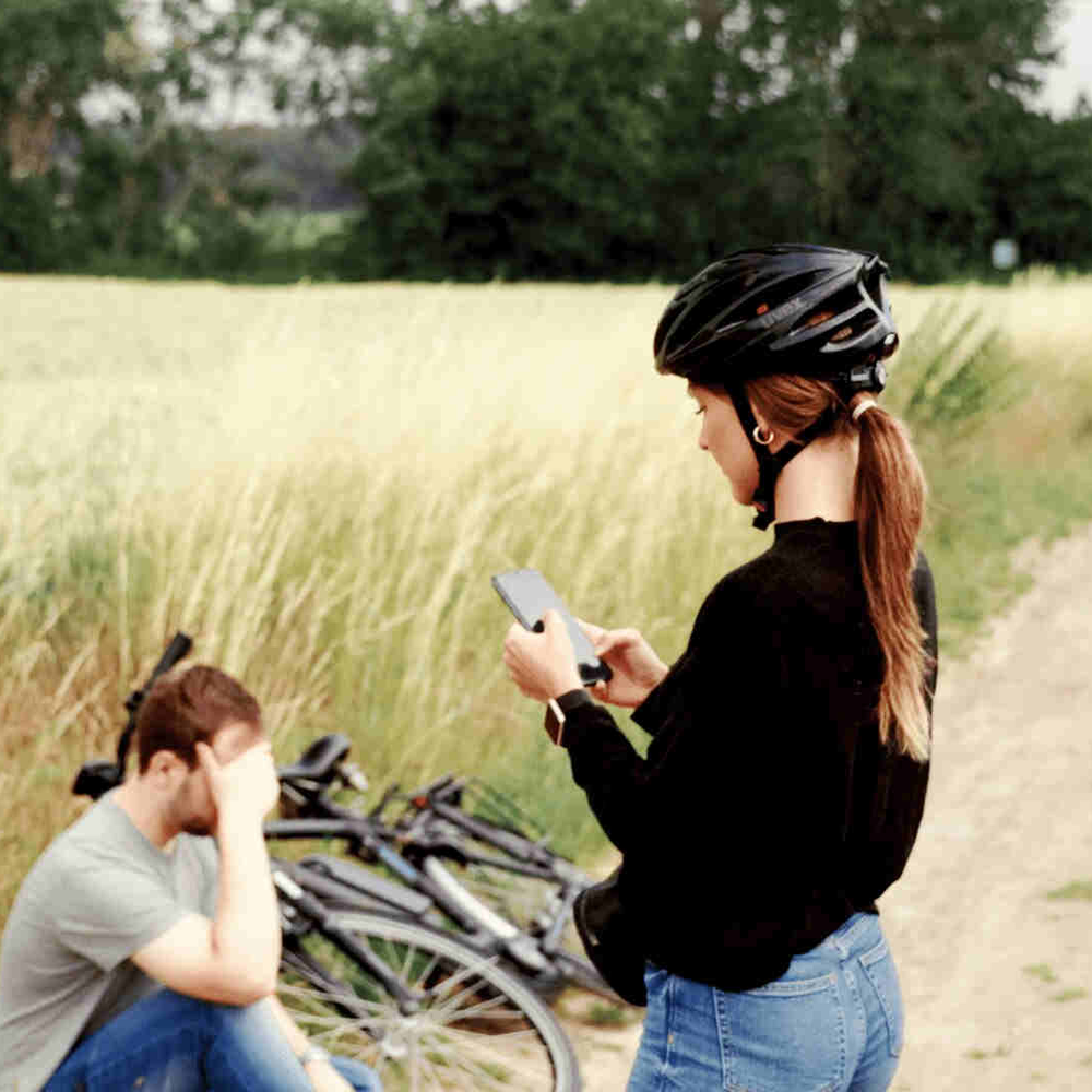 Mann sitzt bei einer Fahrradpanne verzweifelt auf dem Boden und wartet auf den Pannendienst