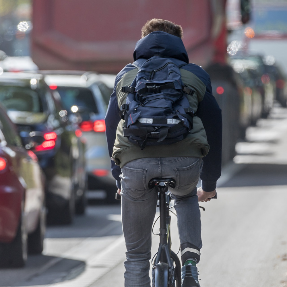 Ein Radfahrer fährt am Stau vorbei. 