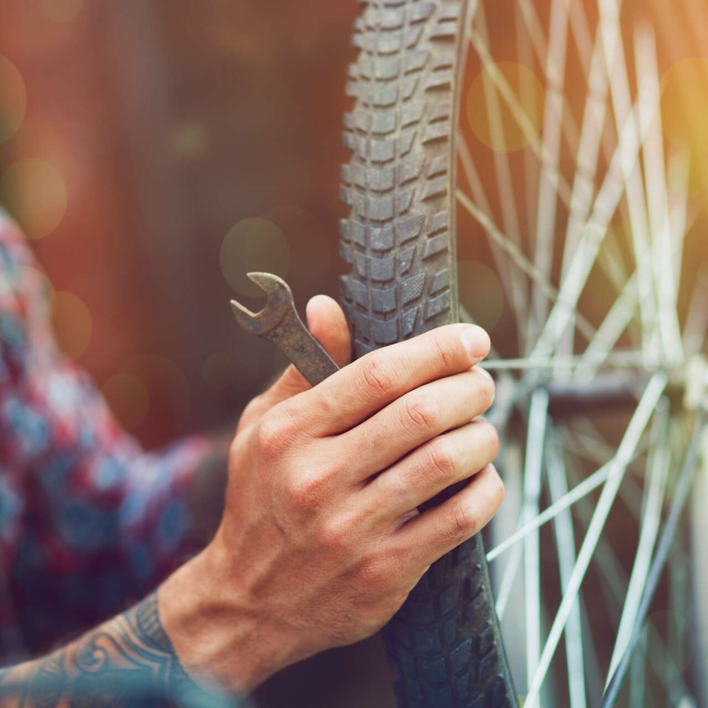 Ein Mann repariert sein Fahrrad.