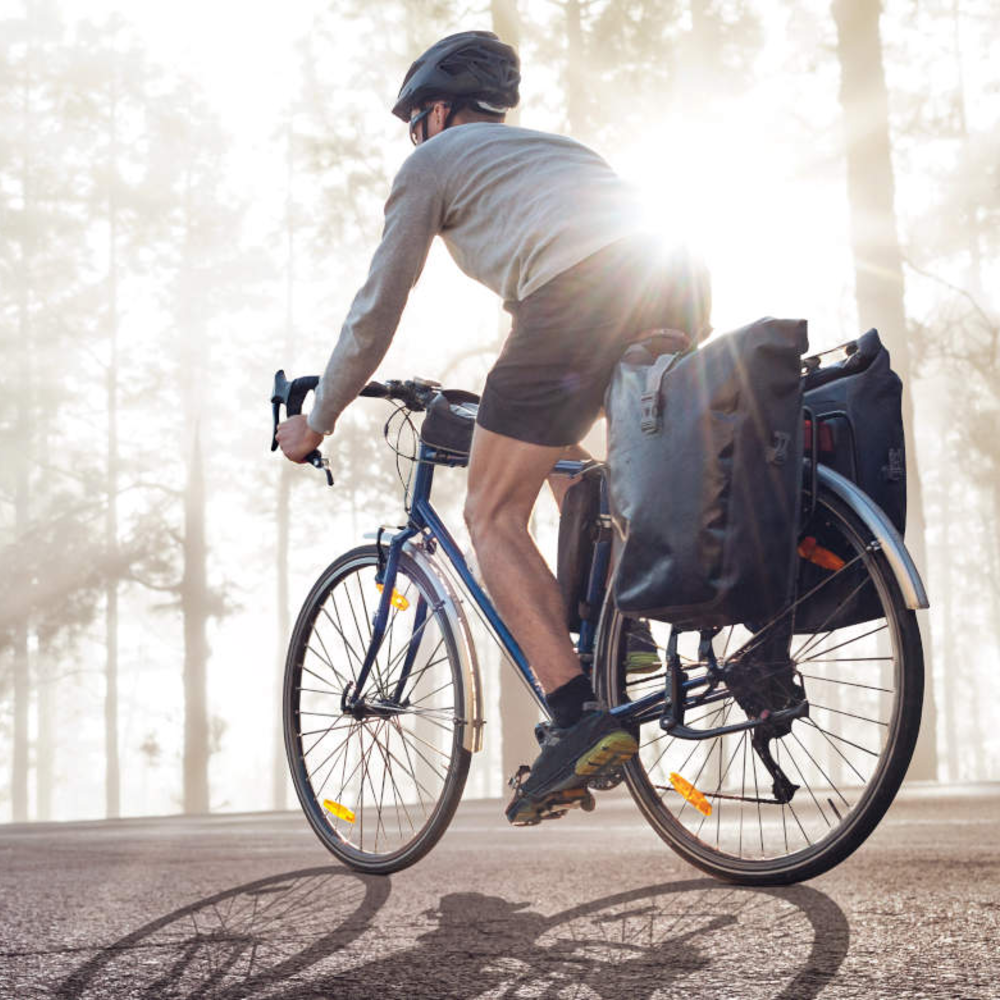 Fahrradfahrer fährt mit seiner Fahrradtasche im Wald