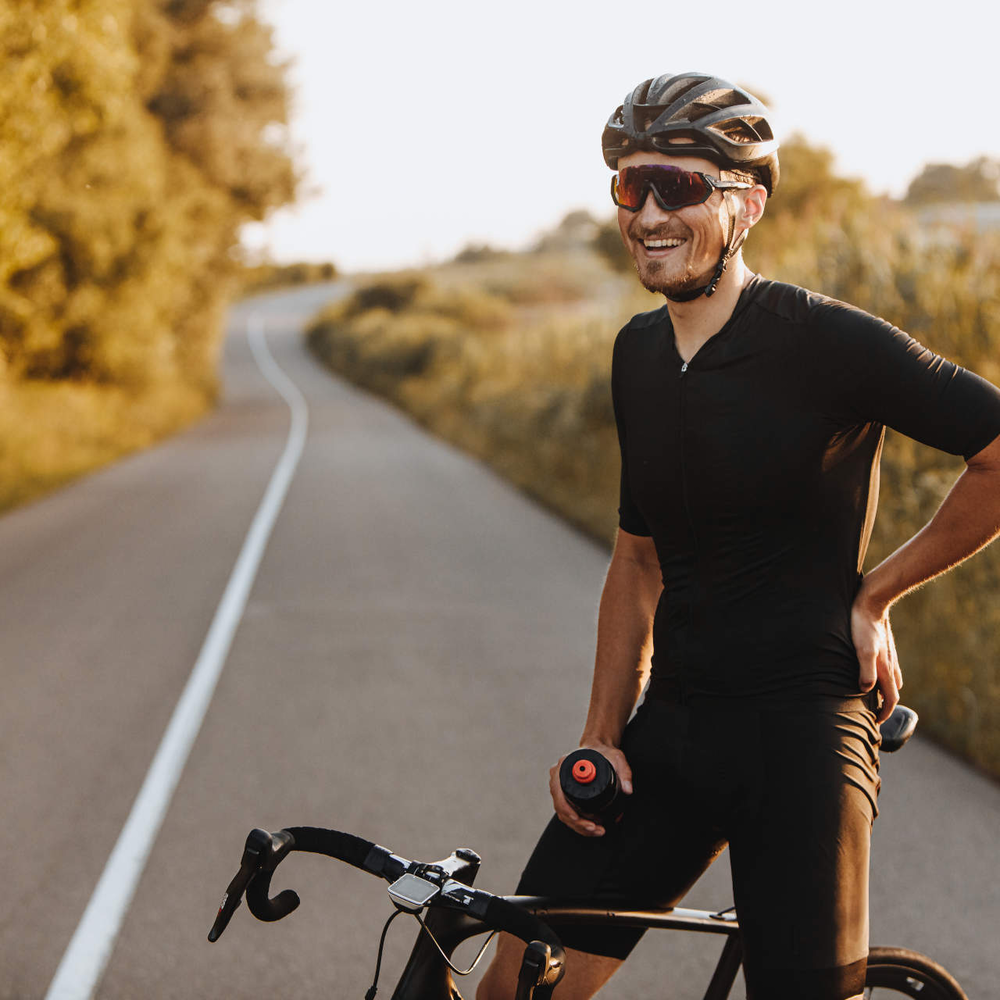 Mann sitzt lächelnd auf Rennrad