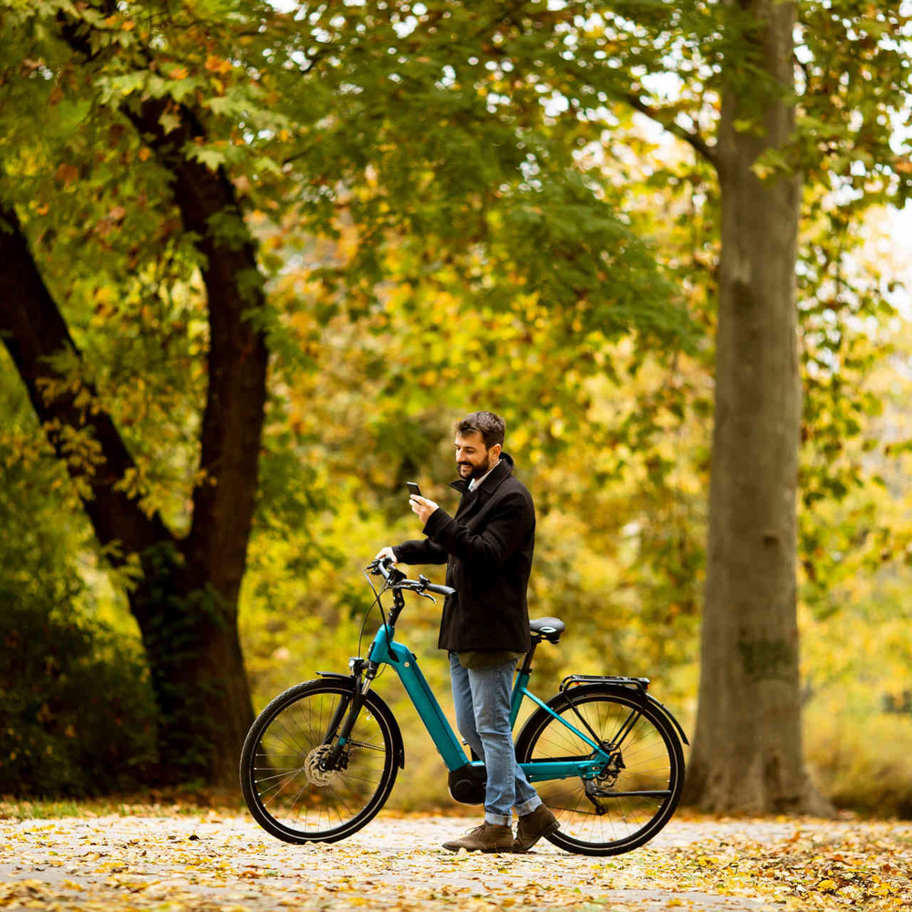 Mann steht neben E-Bike im Stadtpark