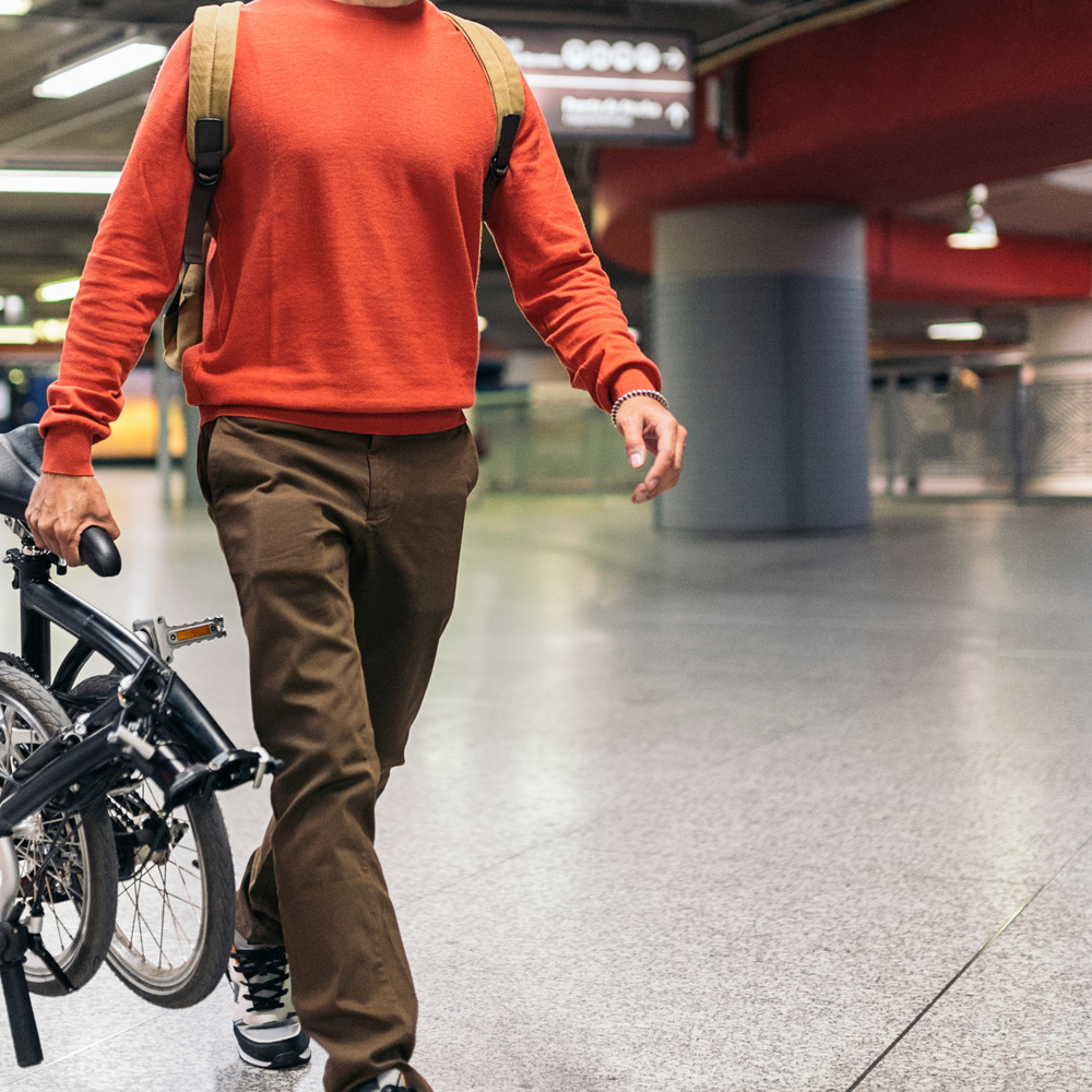 Mann trägt ein Klapprad in der U-Bahn