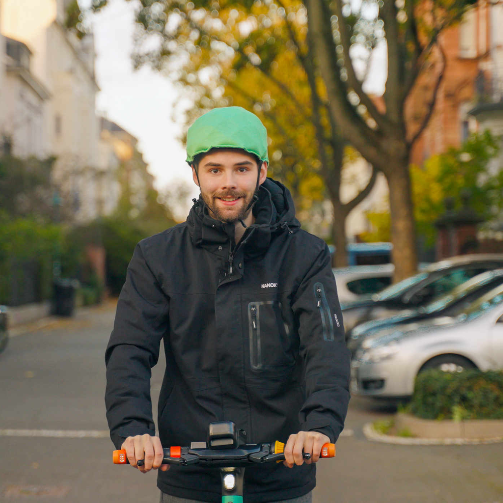 Mann auf E-Scooter fährt mit Inflabi Helm.