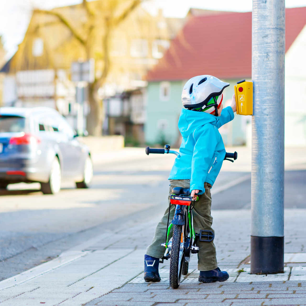 Kind auf Weg zur Schule hält an Ampel