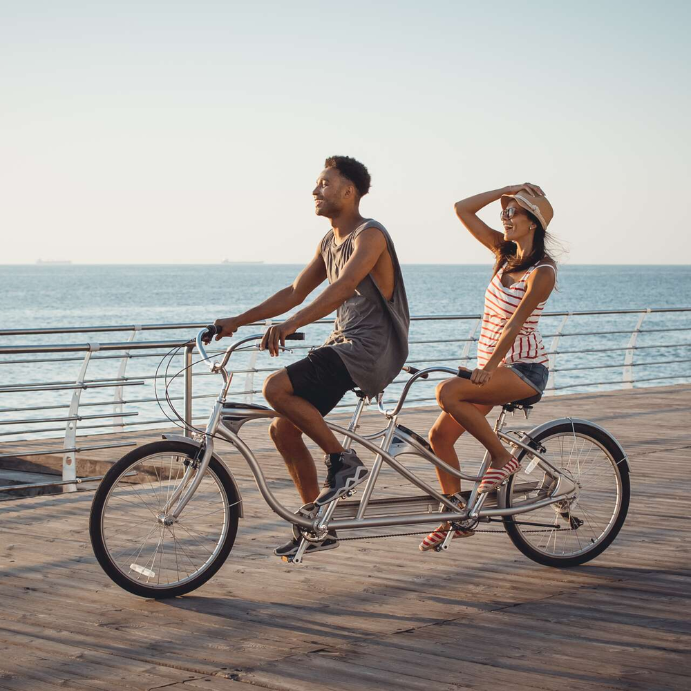 Ein Paar fährt Tandem am Meer. 